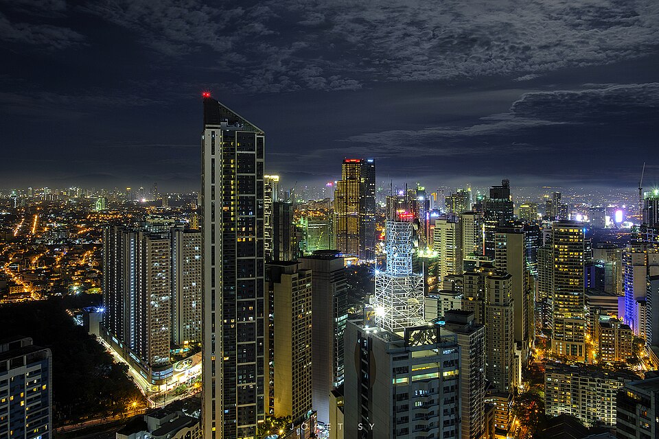 Night view of towers in Makati, Metro Manila, under a cloudy sky