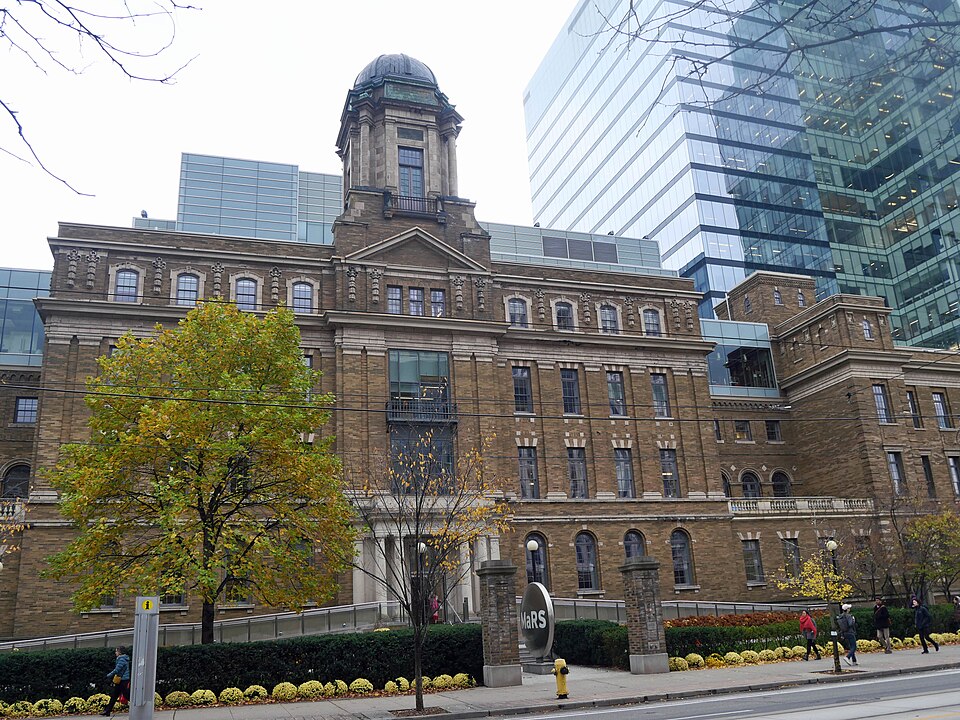 The brick MaRS Discovery District building in downtown Toronto beside a glass tower